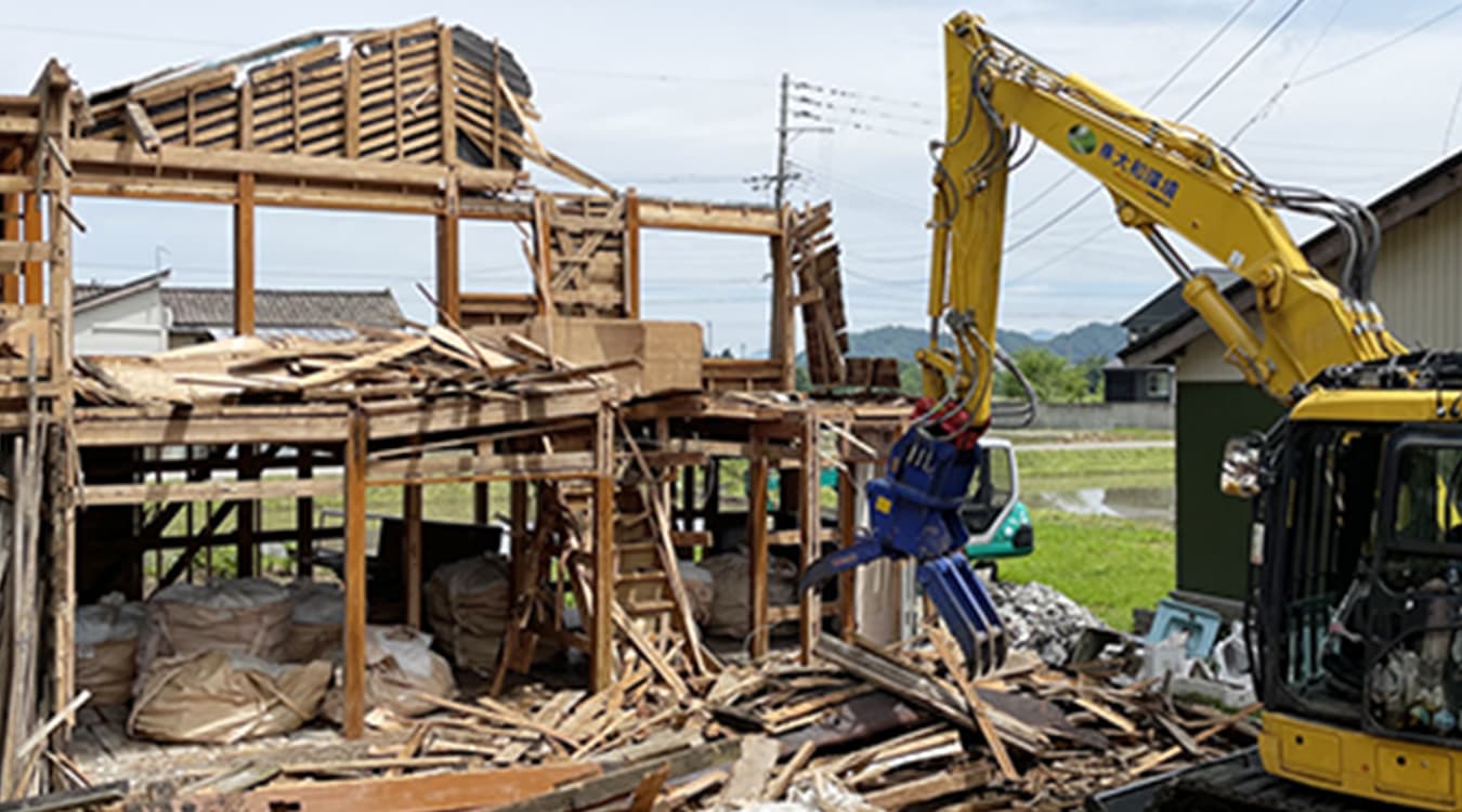 重機（ユンボ）のアタッチメントを使用した木造住宅の解体工事風景