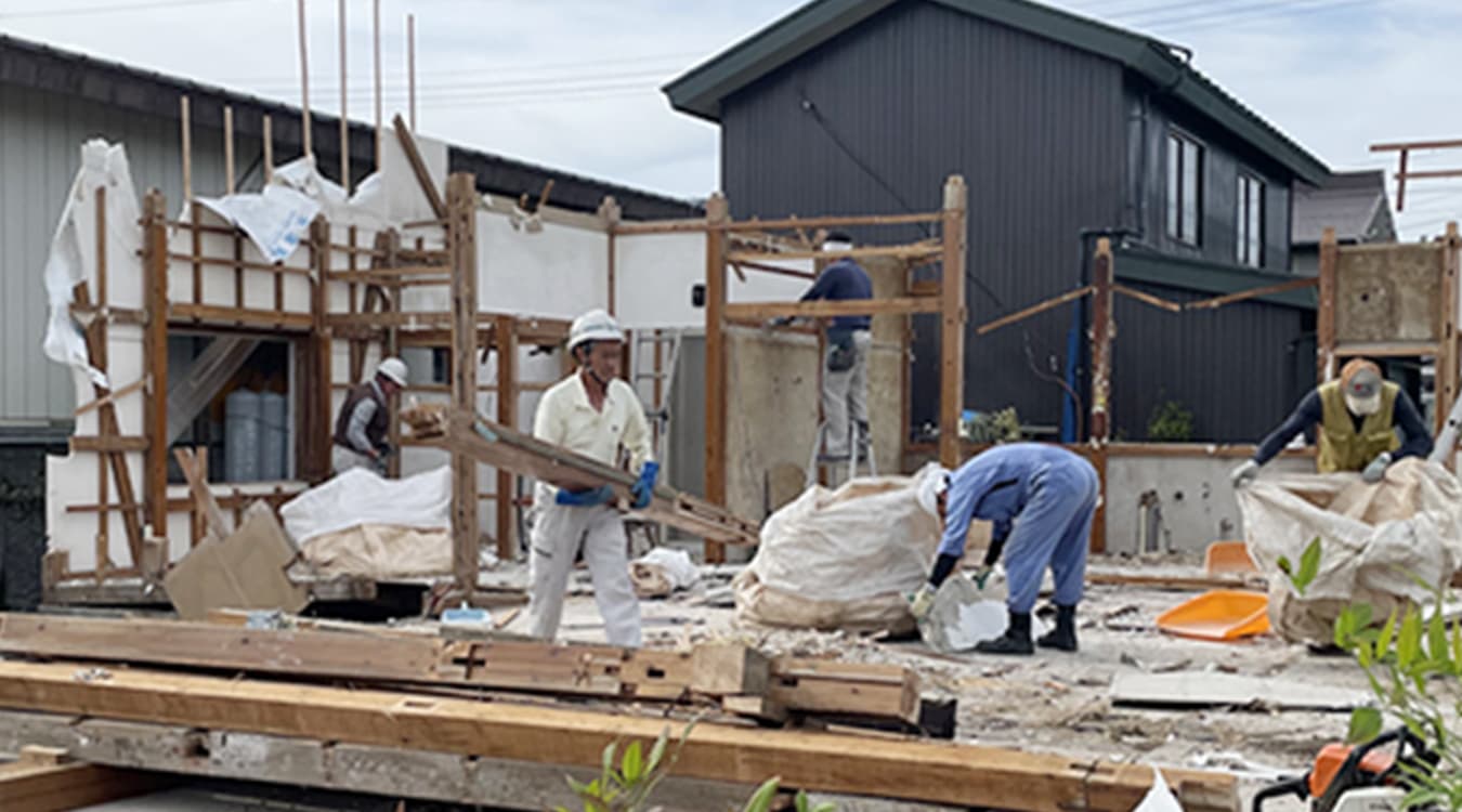 木造家屋の解体工事現場での手作業による分別と廃材搬出の様子