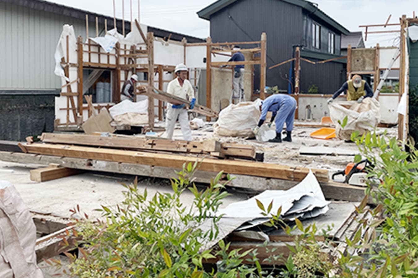木造家屋の骨組みを手作業で解体・分別している工事風景